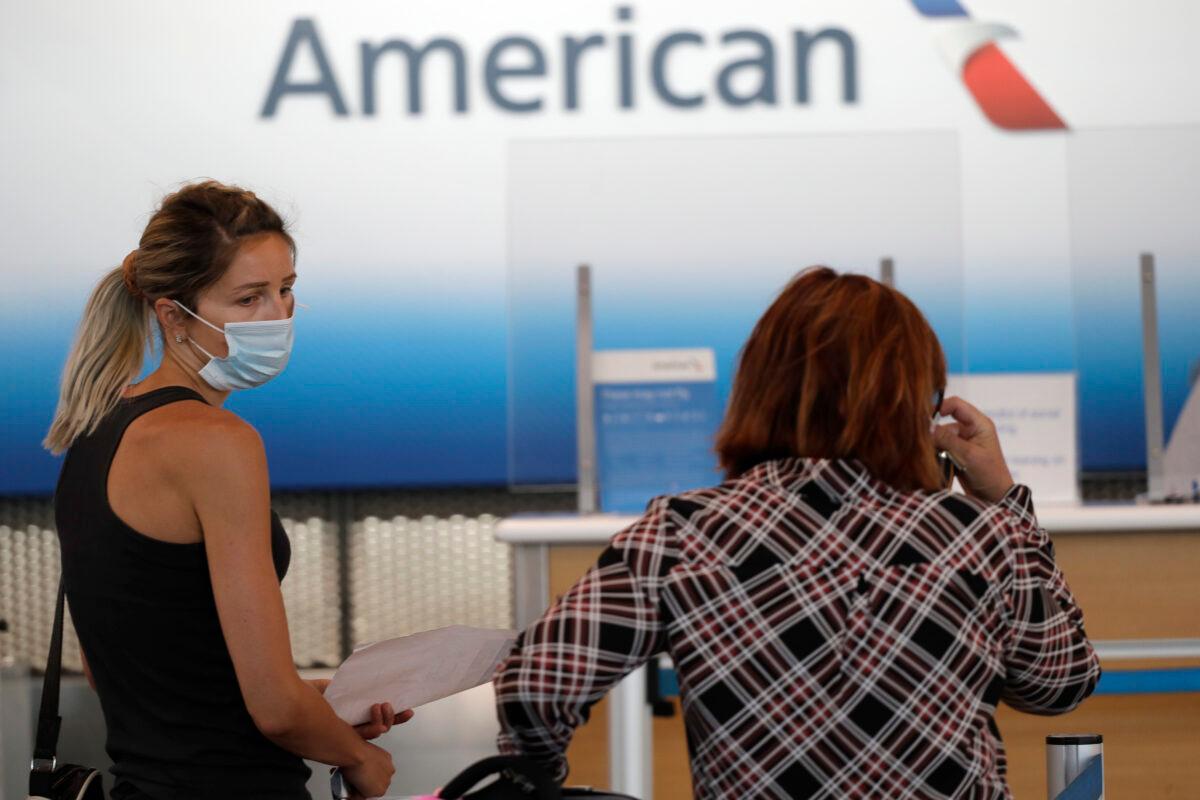 Travelers wear masks as they wait at the American Airlines ticket counter in Terminal 3 at O'Hare International Airport in Chicago on June 16, 2020. (Nam Y. Huh/AP Photo)