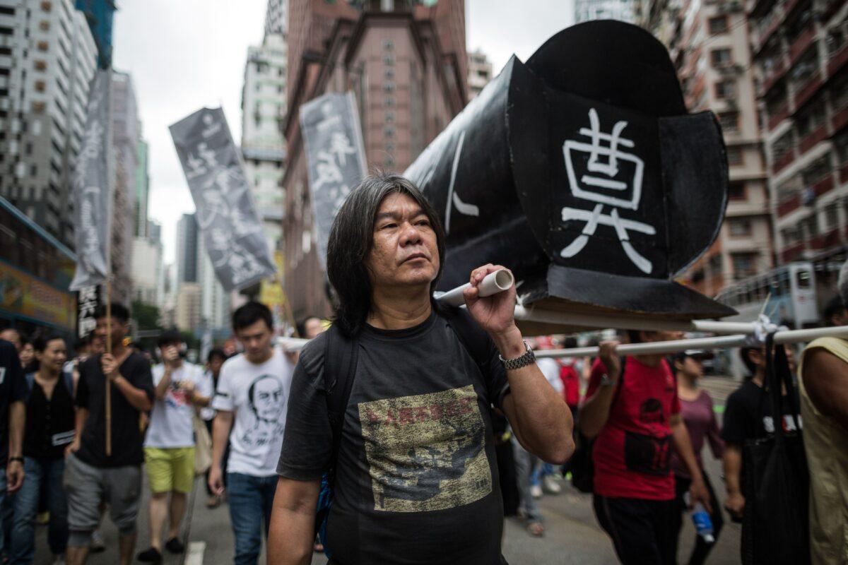 Leung Kwok-hung, known as "Long Hair," helps to support a mock coffin as he attends a rally in Hong Kong on May 31, 2015, to commemorate the 1989 crackdown at Tiananmen Square in Beijing, prior to the incident's 26th anniversary on June 4. (Anthony Wallace/AFP via Getty Images)