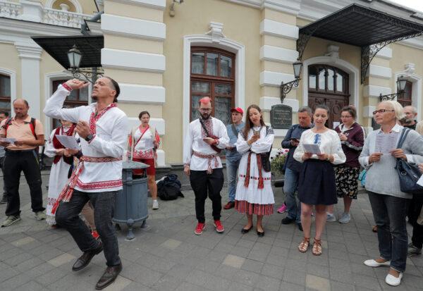 People sing as they attend an opposition demonstration to protest against presidential election results in front of the Janka Kupala National Academic Theater in Minsk on Aug. 20, 2020. (Vasily Fedosenko/Reuters)