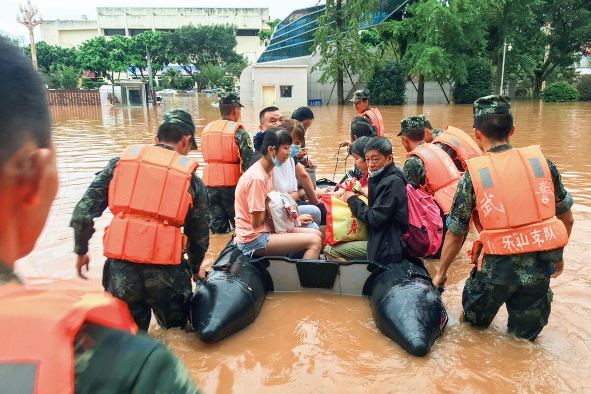 Rescuers evacuating residents at a flooded area following heavy rains in Leshan in China's southwestern Sichuan Province, on Aug. 18, 2020. (STR/AFP via Getty Images)