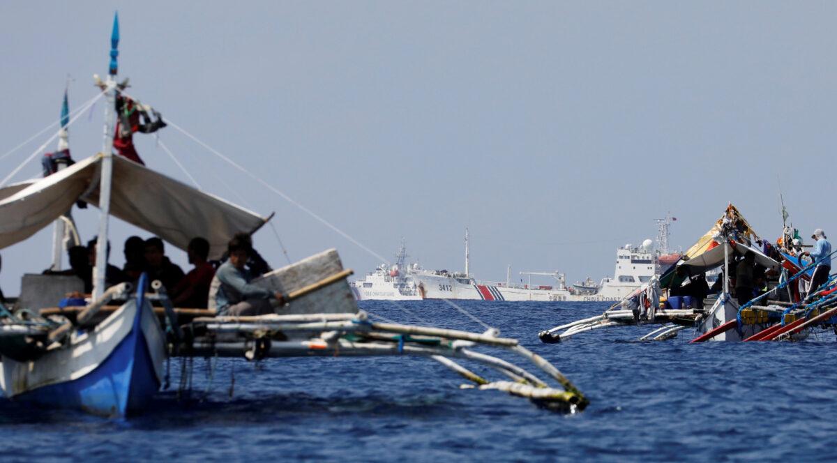 China Coast Guard vessels patrol past Philippine fishing boats at the disputed Scarborough Shoal on April 5, 2017. (Erik De Castro/Reuters)