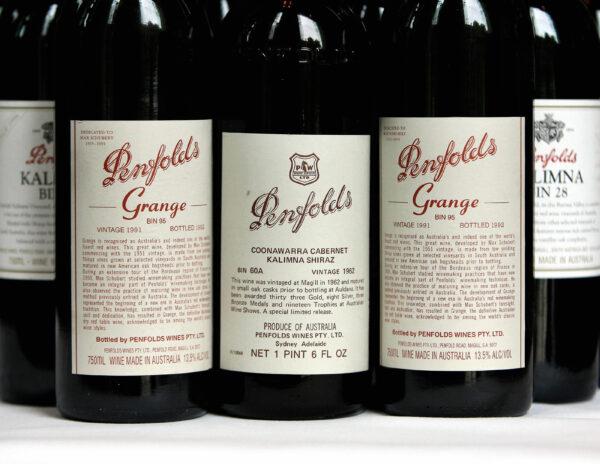 A Penfolds 1962 vintage Cabernet Shiraz (C), voted number seven in a list of 100 of the world's greatest ever wines, is flanked (L and R) by 1991 vintage bottles of the famous Penfolds Grange red wine, at a special re-corking clinic in Sydney, Australia on 12 July 2006. (Greg Wood/AFP via Getty Images)