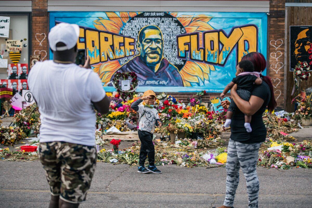 A family takes pictures in front of a mural of George Floyd in Minneapolis, Minn., on May 28, 2020. (Brandon Bell/Getty Images)
