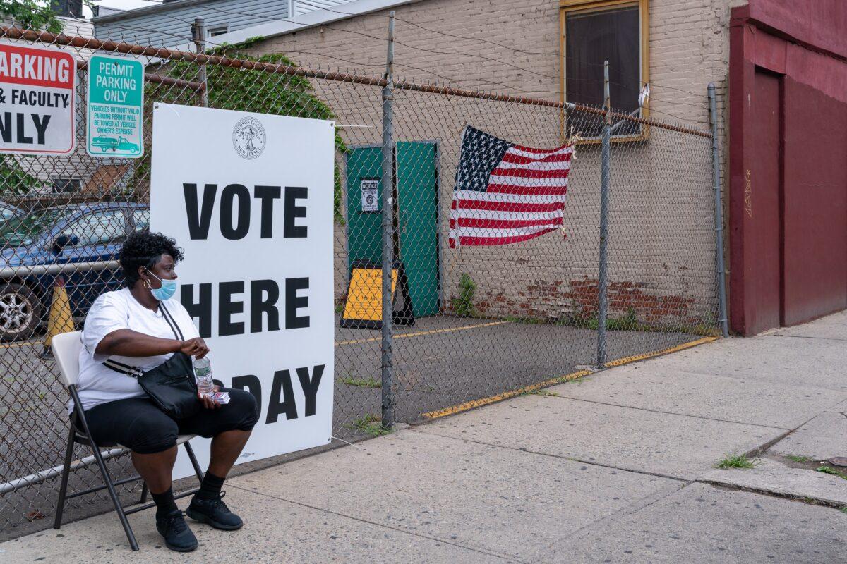A poll worker sits outside of the polling station in Saint Aloysius in Jersey City, N.J. on July 7, 2020. (David Dee Delgado/Getty Images)