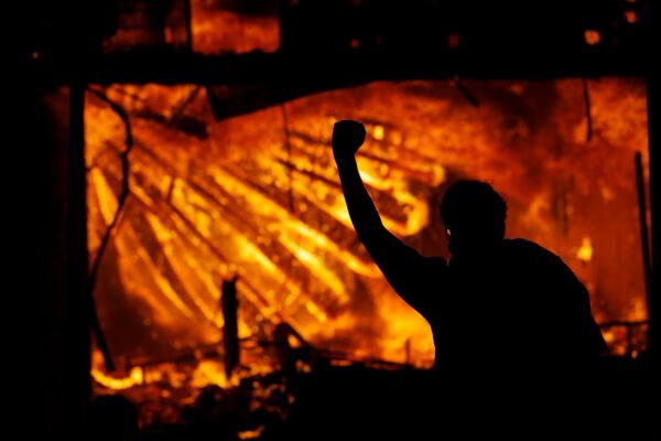 A protester gestures in front of the burning 3rd Precinct building of the Minneapolis Police Department in Minneapolis on May 28, 2020. (Julio Cortez File/AP Photo)