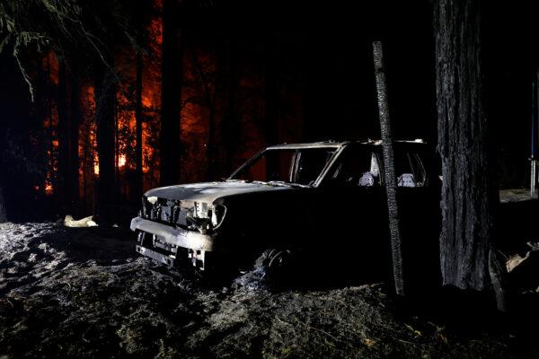 A burned out vehicle is seen along State Route 236 during the CZU Lightning Complex Fire in Boulder Creek, Calif., on Aug. 20, 2020. (Stephen Lam/Reuters)