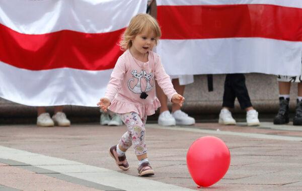 A young girl plays with a balloon during a protest in Minsk on Aug. 23, 2020. (Dmitri Lovetsky/AP Photo)