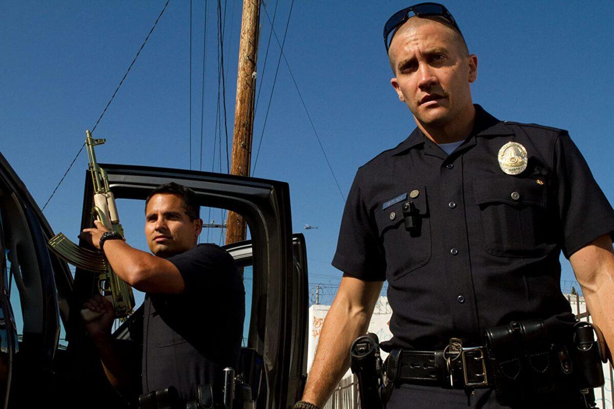 Michael Peña (L) and Jake Gyllenhaal confiscate an illegal AK-47 from cartel gang members in "End of Watch." (Scott Garfield/Open Road Films)