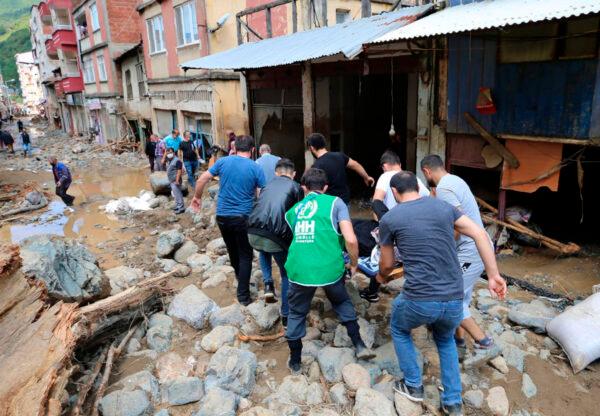 People carry a rescued person from the scene after floods caused by heavy rain in the mountain town of Dereli in Giresun province, along Turkey's Black Sea coastline, on Aug. 23, 2020. (AP Photo)