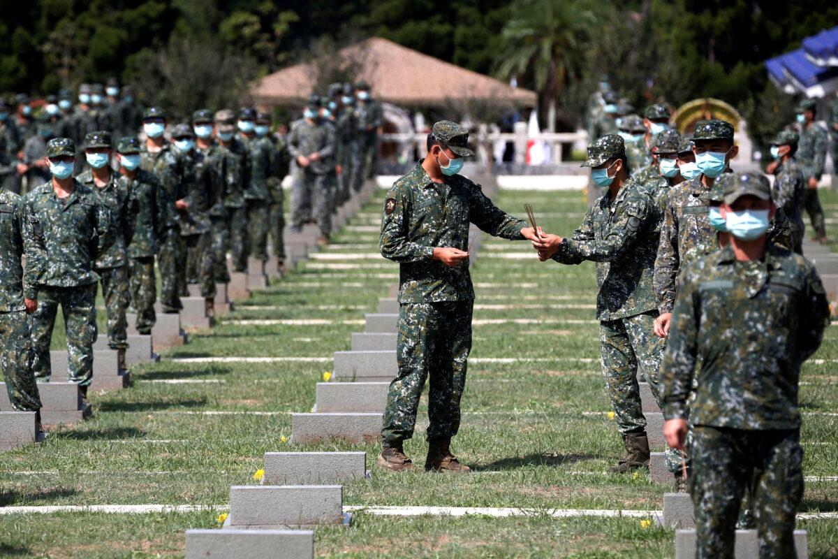 Soldiers pass incense to each other to pay respects to the deceased, during an event to mark the 62nd anniversary of the Second Taiwan Strait crisis in Kinmen, Taiwan, on Aug. 23, 2020. (Ann Wang/Reuters)