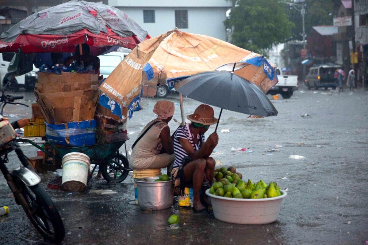 Street vendors protect themselves against the rain from Tropical Storm Laura in Port-au-Prince, Haiti, on Aug. 23, 2020. (Dieu Nalio Chery/AP Photo)
