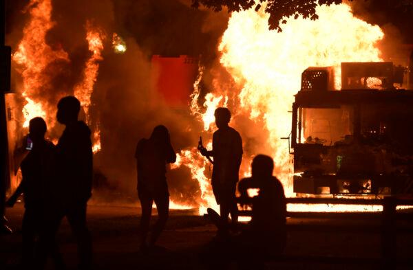 Garbage and dump trucks were set ablaze by rioters near the Kenosha County Courthouse where they had been set up to prevent damage to the building, in Kenosha, Wis., on Aug. 23, 2020. (Sean Krajacic/Kenosha News via AP)