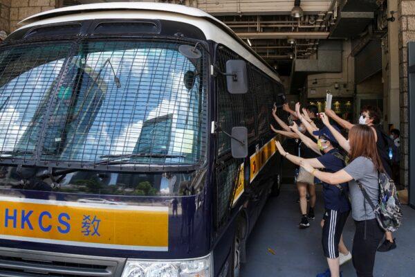 Supporters bid farewell to a prison van transporting Tong Ying-kit, a Hong Kong resident charged under the city's new national security law, who has been denied bail again in Hong Kong, China, on Aug. 25, 2020. (Lam Yik via Reuters)