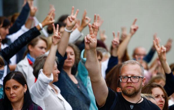 People gesture as they take part in a rally against presidential election results near the Ministry of Education in Minsk on August 25, 2020. (Vasily Fedosenko/Reuters)