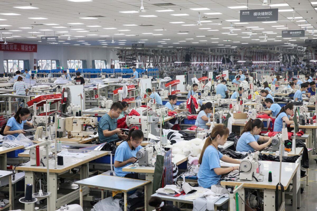 Employees produce down coats at a factory for Chinese clothing company Bosideng in Nantong, Jiangsu Province, China, on Sept. 24, 2019. (STR/AFP via Getty Images)