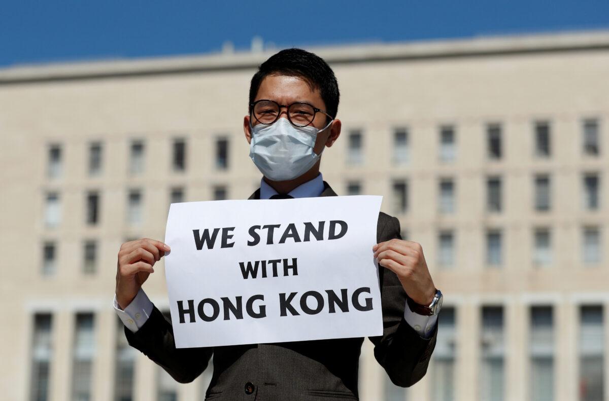 Exiled Hong Kong pro-democracy activist Nathan Law holds a placard outside the Italian Foreign Ministry, ahead of a meeting between Italian Foreign Minister Luigi di Maio and his Chinese counterpart, Wang Yi, in Rome, Italy, on Aug. 25, 2020. (Yara Nard/ Reuters)
