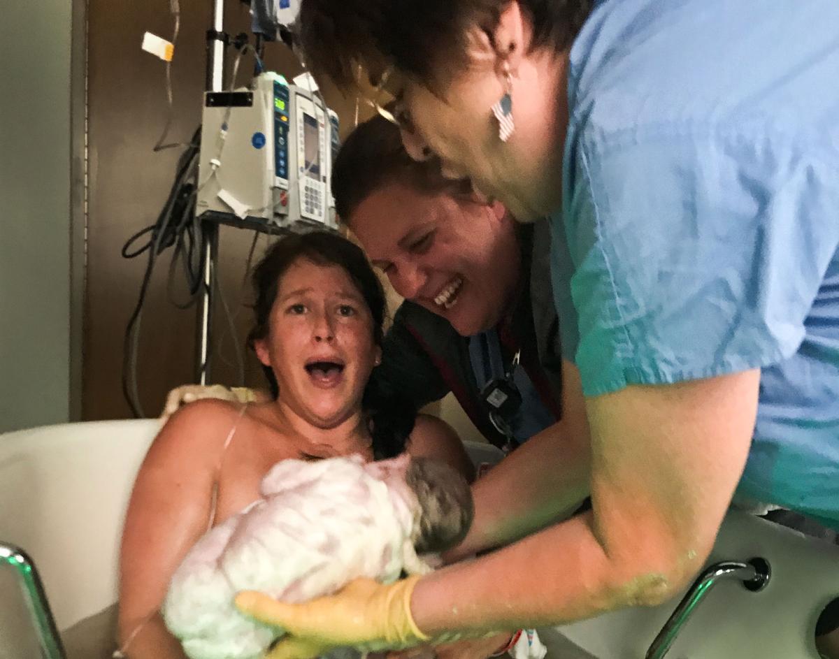 Lyndsey Altice, 30, completely shocked as she is handed her twin girls. (Caters News)