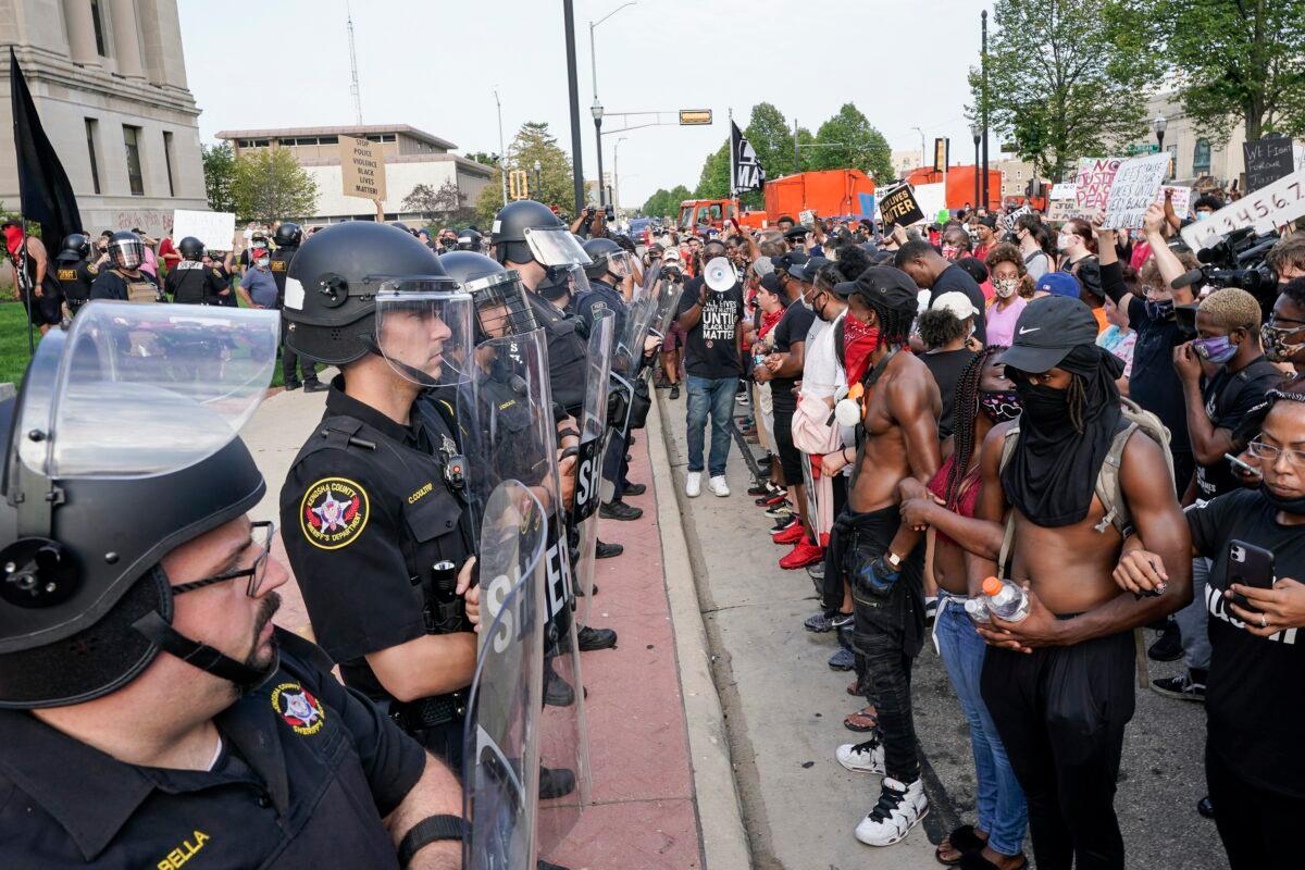 Protesters link arms in front of a police line outside the Kenosha County Courthouse in Kenosha, Wis., on Aug. 24, 2020. (Morry Gash/AP Photo)