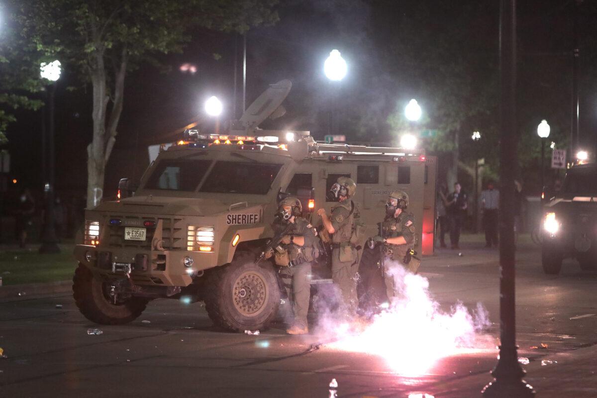 An explosive device detonates next to police officers standing guard in front of the Kenosha County Courthouse in Kenosha, Wis., on Aug. 24, 2020. (Scott Olson/Getty Images)