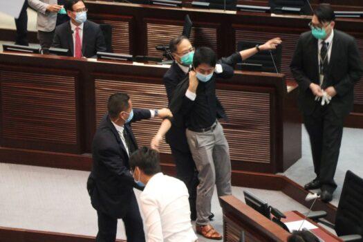 Security officers hold pro-democracy lawmaker Ted Hui who splashed liquid at the Legislative Council chamber during a meeting on the controversial national anthem bill in Hong Kong, China, on June 4, 2020. (Jessie Pang via Reuters)