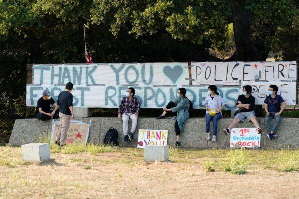 Students and researchers at UC Santa Cruz sit in front of a sign thanking first responders for their efforts in fighting the CZU August Lightning Complex Fire in Santa Cruz, Calif., on Aug. 24, 2020. (Marcio Jose Sanchez/AP Photo)