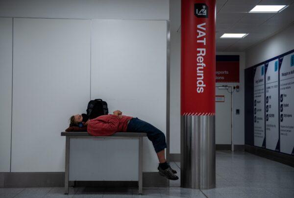 An airline passenger lies on a table inside the South Terminal at London Gatwick Airport on June 9, 2020. (Chris J Ratcliffe/Getty Images)