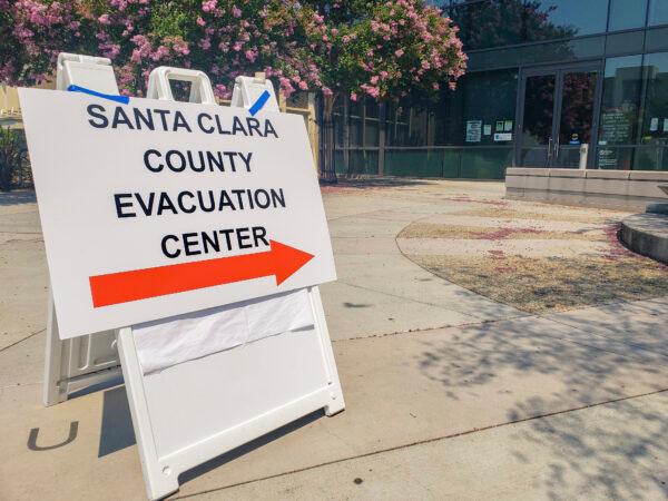 A sign outside the Milpitas Library directs evacuees to a resource center within, in Milpitas, Calif., on Aug. 21, 2020. (David Lam/The Epoch Times)