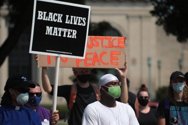 A Black Lives Matter sign is held up as people gather in front of a police station the day after Jacob Blake was shot by police officers, in Kenosha, Wis., Aug. 24, 2020. (Scott Olson/Getty Images)