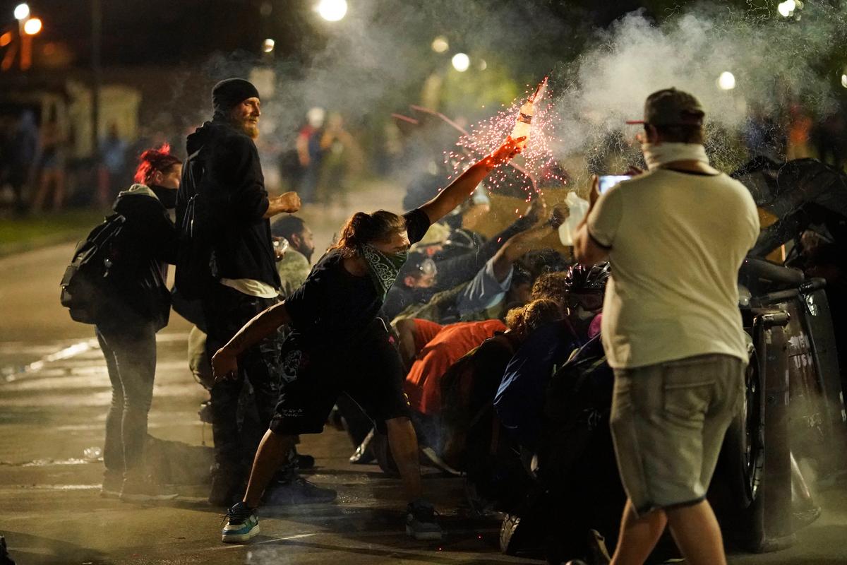 A rioter tosses an object toward police during clashes outside the Kenosha County Courthouse in Kenosha, Wis., on Aug. 25, 2020. (David Goldman/AP Photo)
