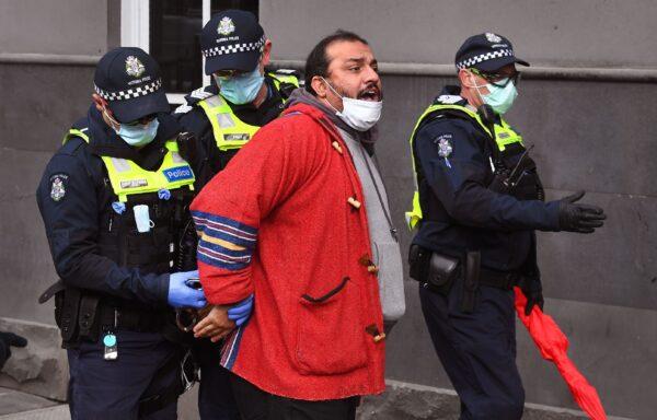 Police detain a protester at a small-scale rally against COVID-19 restrictions in Melbourne on Aug. 9, 2020. (William West via Getty Images)