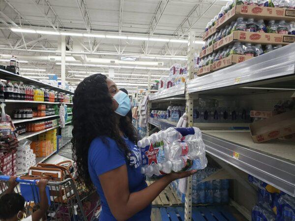 Shakesa White shops for essentials in preparation for the effects from Hurricane Laura at Natchez, Miss. Walmart on Seargent Prentiss Drive on the evening of Aug. 26, 2020. (Sabrina Robertson/The Natchez Democrat via AP)