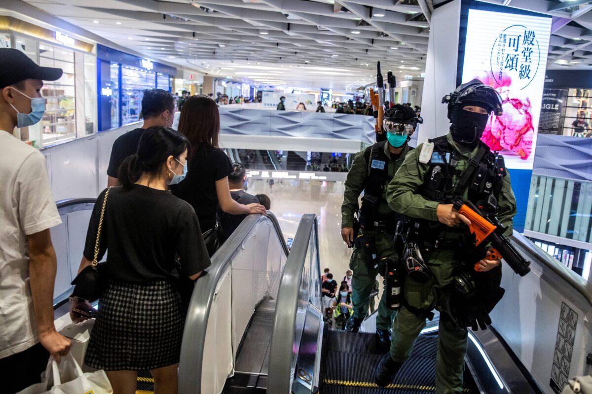 Riot police (R) arrive for a clearance operation after district councilors protested inside a mall at Yuen Long in Hong Kong on July 19, 2020, against a mob attack by suspected triad gang members inside the Yuen Long train station on July 21, 2019. (Isaac Lawrence/AFP via Getty Images)