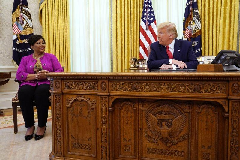 President Donald Trump speaks with Alice Marie Johnson as he issues a full pardon for Johnson in Oval Office of the White House on Aug. 28, 2020. (AP Photo/Evan Vucci)