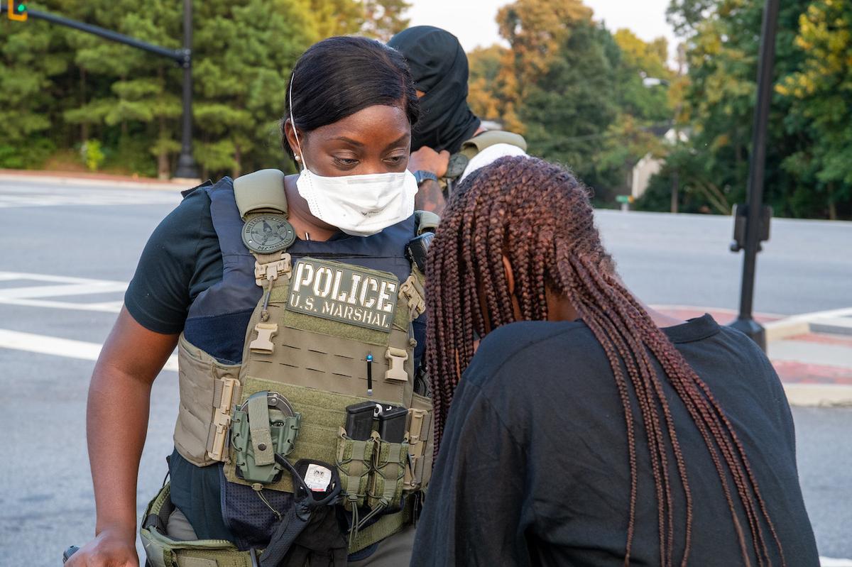  A U.S. Marshal, who is involved in a missing child mission called "Operation Not Forgotten," speaks to a possible victim in either Atlanta or Macon, Georgia, in early August 2020. (Shane T. McCoy/US Marshals/CC by 2.0)