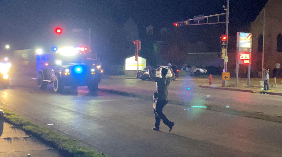In this still image, a man with a firearm, later identified as Kyle Rittenhouse, raises his hands up as he walks towards vehicles during a riot in Kenosha, Wis. on Aug. 25, 2020. (Brendan Gutenschwager/via Reuters)