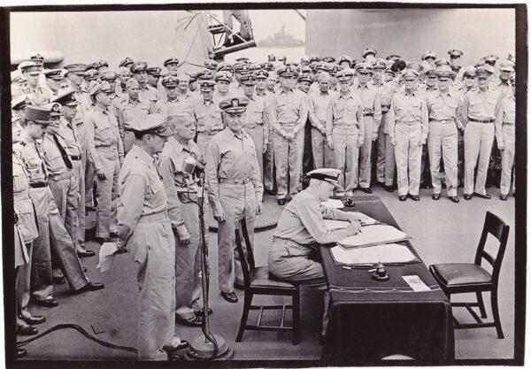 Fleet Admiral Chester Nimitz signing the surrender agreement on behalf of the United States aboard the USS Missouri in Tokyo Bay on Sept. 2, 1945. This print is from the original photograph negative. (National Museum of the Pacific War)