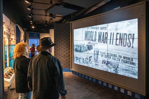 Visitors seeing a newspaper report of Japan’s surrender during World War II. (National Museum of the Pacific War)