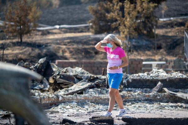 Carol Schafer walks past what remains of her home along Cantelow Road destroyed by the LNU Lightning Complex fires in Vacaville, Calif., on Aug. 26, 2020. (Anda Chu/Bay Area News Group)