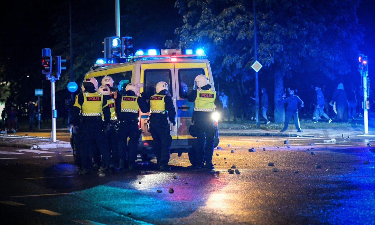 Demonstrators throw stones at police officers during a riot in the Rosengard neighbourhood of Malmo, Sweden, on Aug. 28, 2020. (TT News Agency via Reuters)