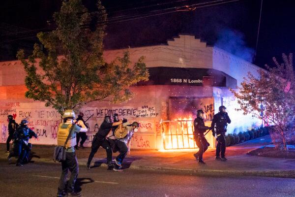 Portland police disperse a crowd after protesters set fire to the Portland Police Association (PPA) building early in the morning in Portland, Oregon on Aug. 29, 2020. (Nathan Howard/Getty Images)