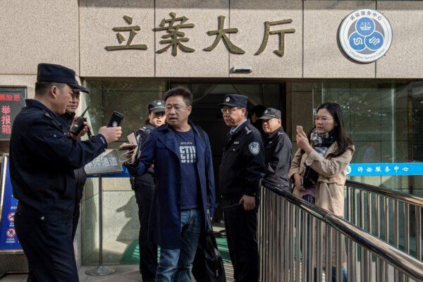 Lawyer Xie Yang (center) accompanied his client Xu Yan (right), wife of human rights lawyer Yu Wensheng, are trying to meet with Yu in person outside the Xuzhou Intermediate Court in Xuzhou, in eastern China’s Jiangsu Province, on Oct. 31, 2019. (Nicolas Asfouri/AFP via Getty Images)