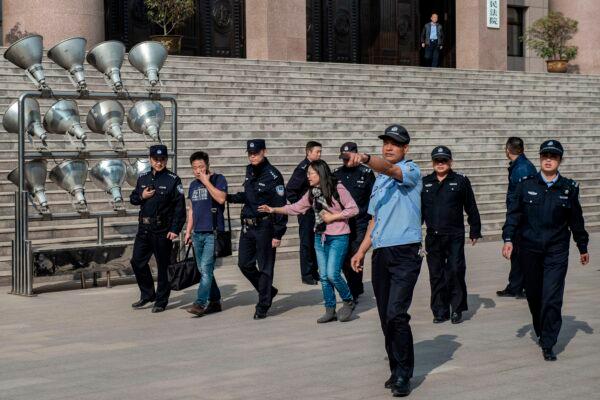 Xu Yan (C), wife of human rights lawyer Yu Wensheng, and her lawyer Xie Yang (2nd L), being escorted to the exit by security personnel outside the Xuzhou Intermediate Peoples Court in Xuzhou city, China, on October 31, 2019. (NICOLAS ASFOURI/AFP via Getty Images)