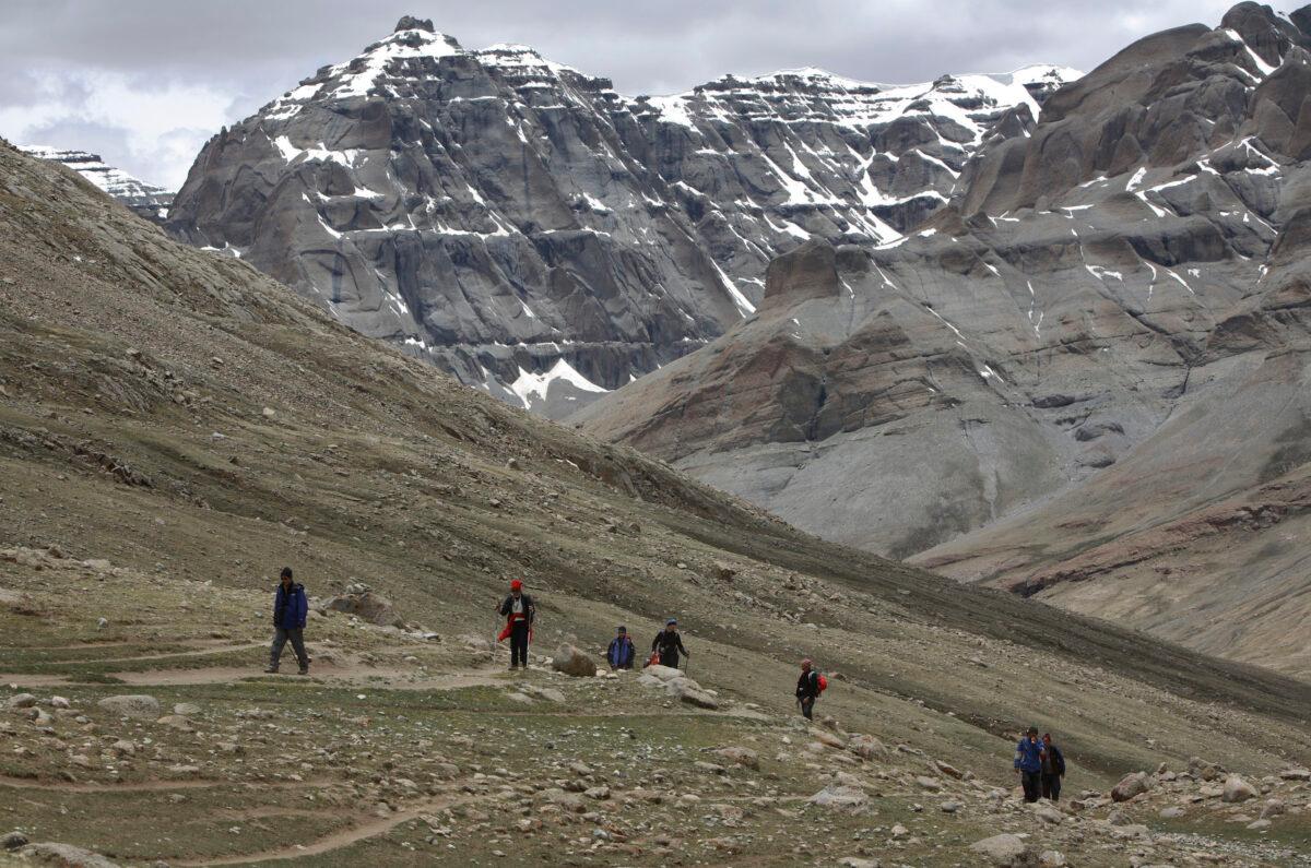 Religious faithful hike around the snow-capped Kangrinboqe Mountain, known as Mt. Kailash in the West, June 15, 2007 in Purang County of Tibet Autonomous Region, China. (China Photos/Getty Images)