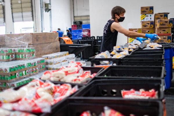 A volunteer sorts food at The Saddleback Church Food Pantry in Lake Forest, Calif., on Aug. 17, 2020. (John Fredricks/The Epoch Times)
