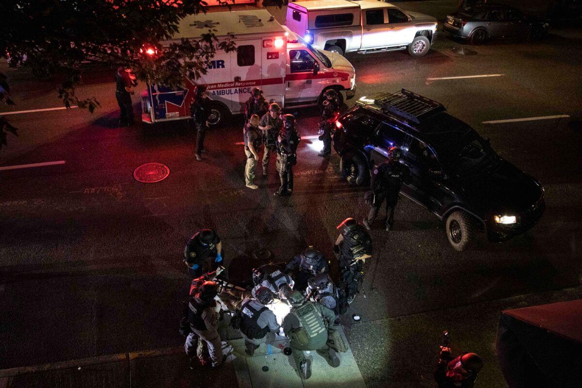 A man is being treated by medics after being shot during a confrontation in Portland, Ore., on Aug. 29, 2020. (AP Photo/Paula Bronstein)