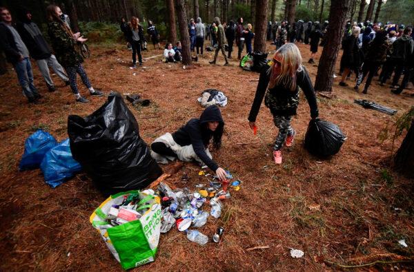 Revellers tidy up rubbish after a suspected illegal rave in Thetford Forest, in Norfolk, Britain, on Aug. 30, 2020. (Reuters/Toby Melville)