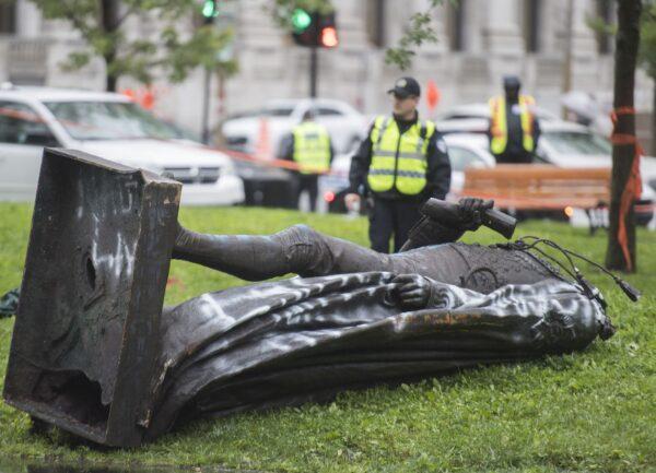 The statue of Sir John A. MacDonald lies headless on the grass after it was torn down following a demonstration in Montreal on Aug. 29, 2020. (Graham Hughes/The Canadian Press)