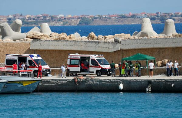 Emergency services are seen on the dock of Le Castella after a migrant boat caught fire during rescue operations off the coast of Crotone, with some people still missing, according to Italian media, in Italy, on Aug. 30, 2020. (Remo Casilli/Reuters)