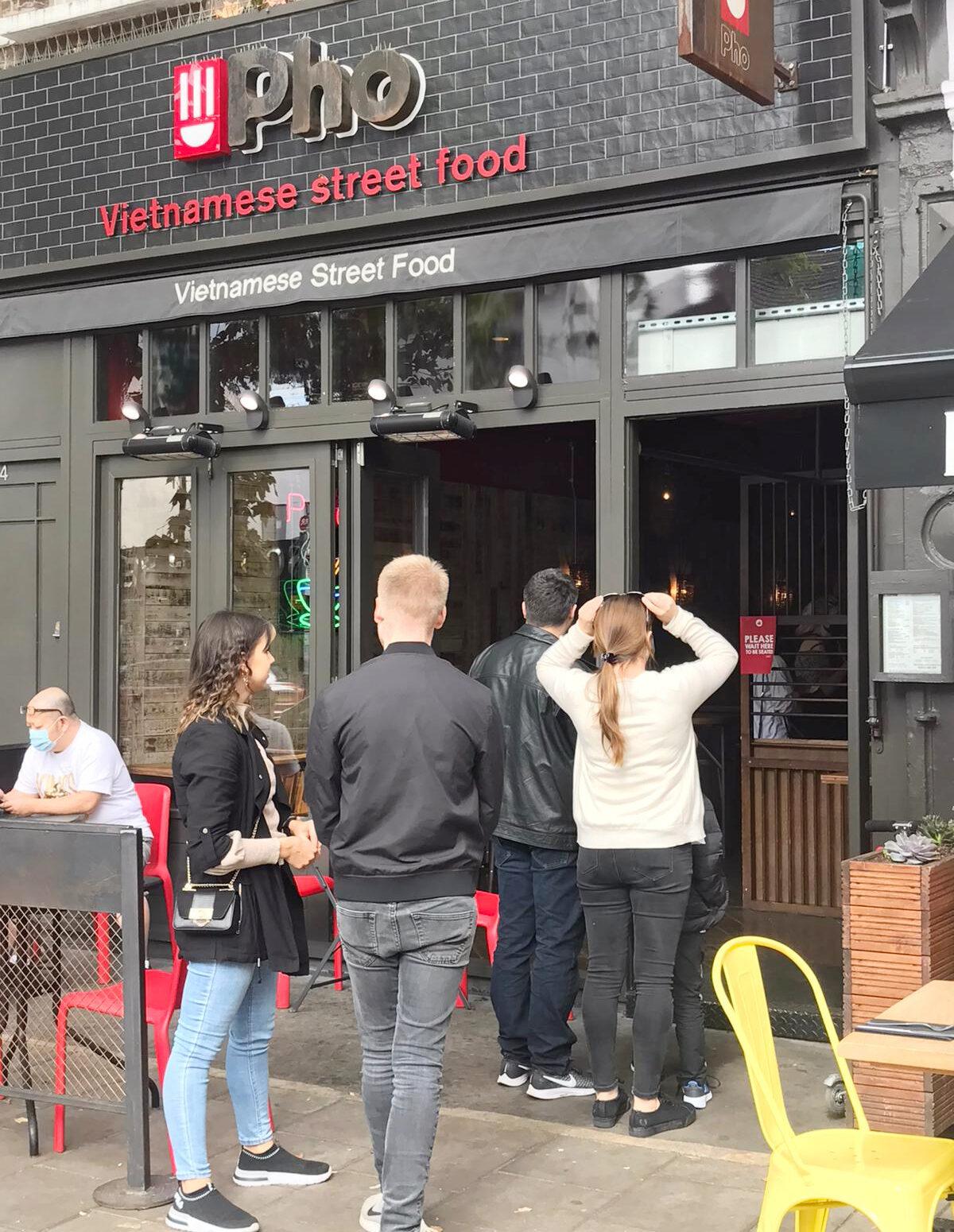Customers queuing outside a restaurant on the last day of the "Eat Out to Help Out" scheme, which pays for half of their restaurant bills, in London, on Aug. 31, 2020. (Sharon Hsu/The Epoch Times)