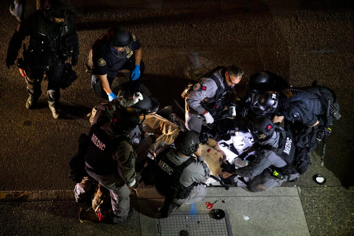 A man is treated after being shot in Portland, Ore., on Aug. 29, 2020. The man, later identified as Aaron Danielson, died from his wounds. (Paula Bronstein/AP Photo)